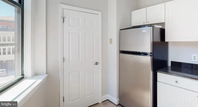 a view of a kitchen with a refrigerator and cabinets