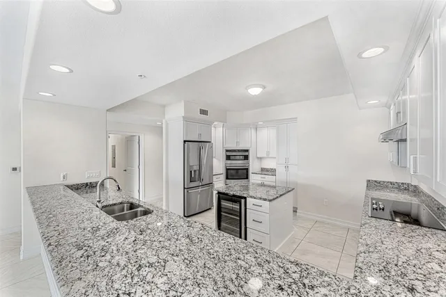 a kitchen with granite countertop a sink stove and cabinets