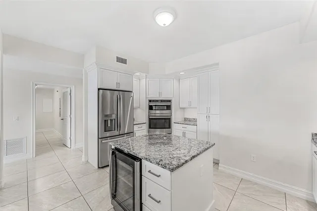 a kitchen with granite countertop a sink and cabinets