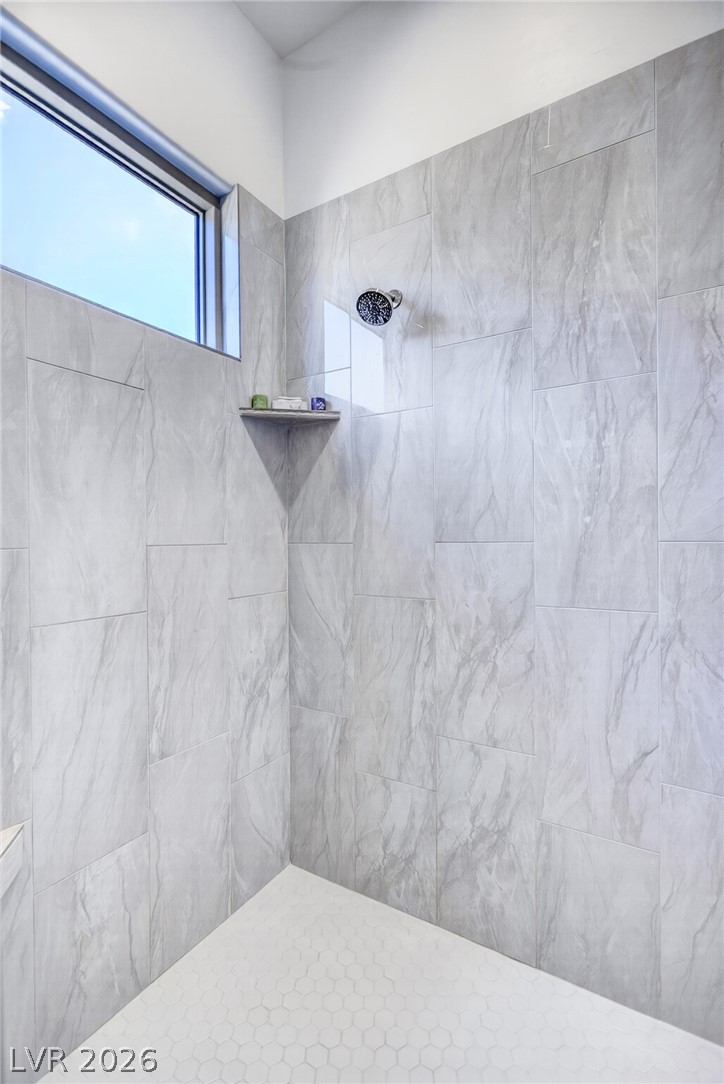 1460 Blue Ridge Trail Mesquite, NV 89027 - Photo 18 of 39 Marble-look tile and hexagonal flooring create a pristine shower environment with natural light from a high window.