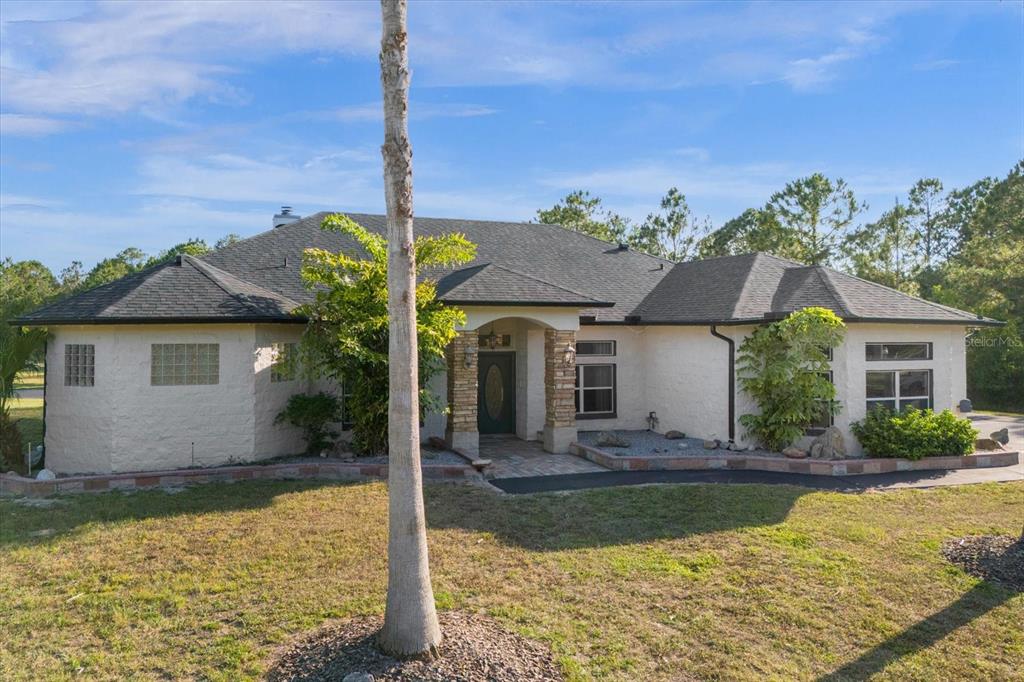 2975 West Osceola Road Geneva, FL 32732 - Photo 3 of 45 a front view of house with yard and trees in the background