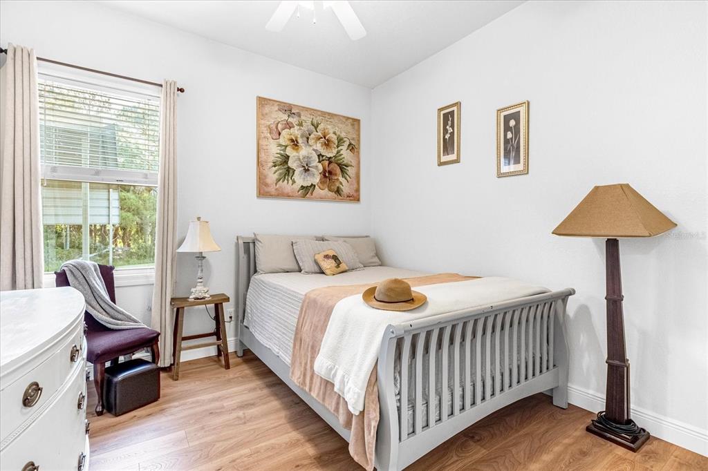 2975 West Osceola Road Geneva, FL 32732 - Photo 33 of 45 a bedroom with a bed and a lamp on table with wooden floor