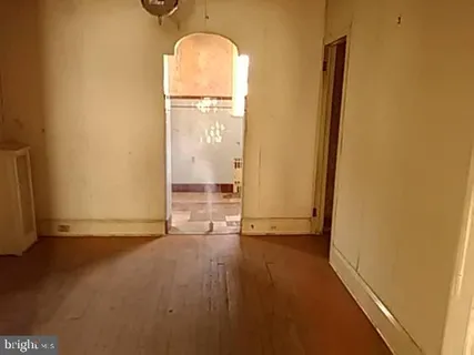 an empty room with wooden floor and a window