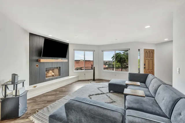 a living room with furniture a fireplace and a flat screen tv