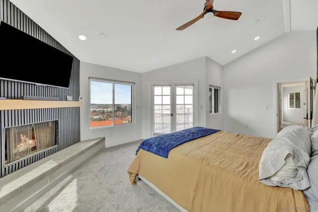 a spacious bedroom with a bed and a flat screen tv