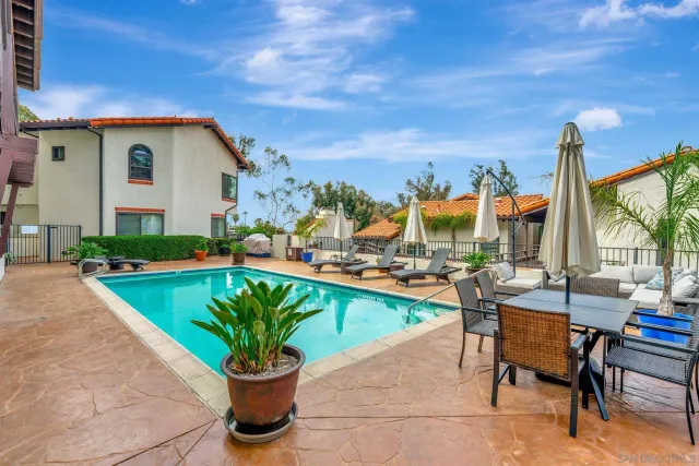 a view of a patio with a dining table and chairs with potted plants