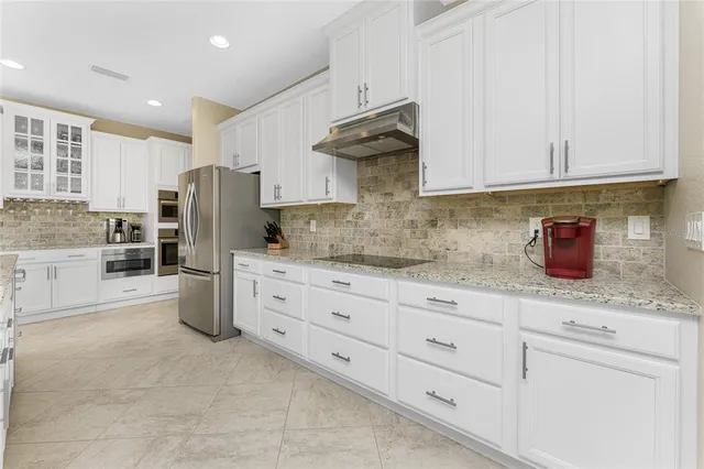 a open kitchen with stainless steel appliances granite countertop a stove and a refrigerator