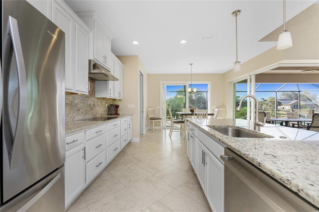 199 Marker Road Rotonda West, FL 33947 - Photo 19 of 55 a large kitchen with kitchen island a large counter top space a sink stainless steel appliances and cabinets