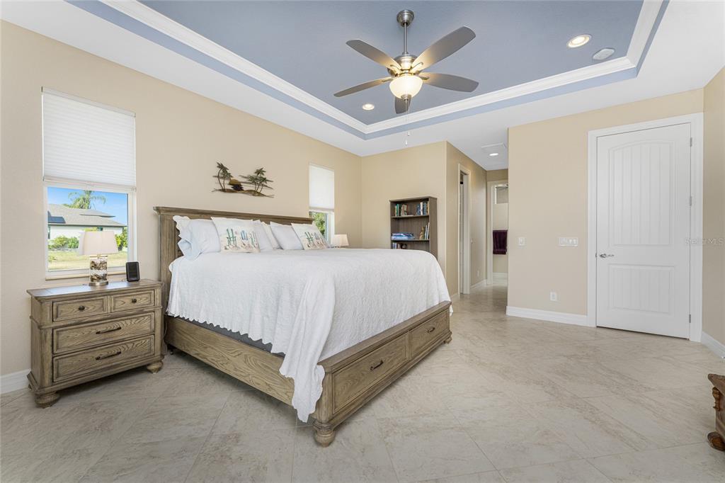 199 Marker Road Rotonda West, FL 33947 - Photo 22 of 55 a spacious bedroom with a bed and a chandelier