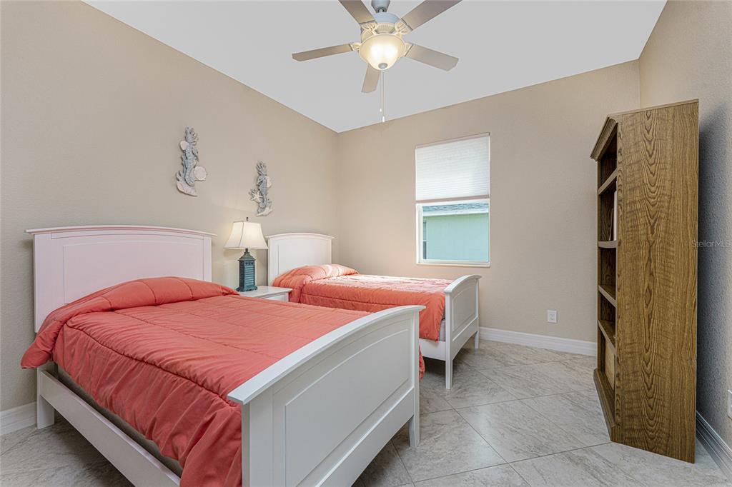 199 Marker Road Rotonda West, FL 33947 - Photo 28 of 55 a bedroom with 2 bed and a chandelier