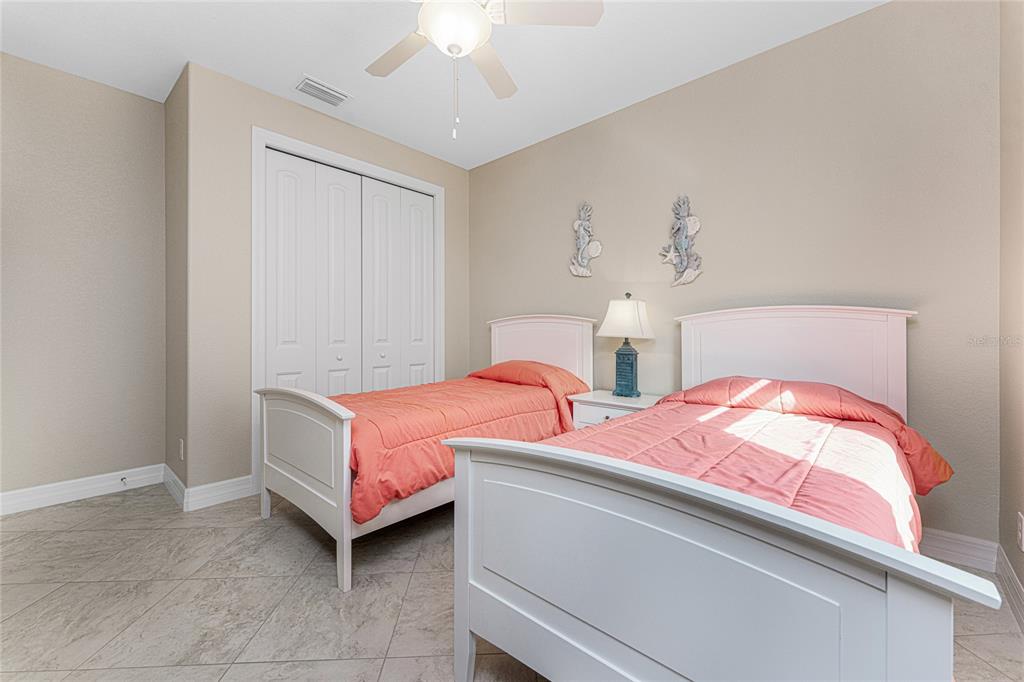 199 Marker Road Rotonda West, FL 33947 - Photo 29 of 55 a bedroom with two beds and a chandelier