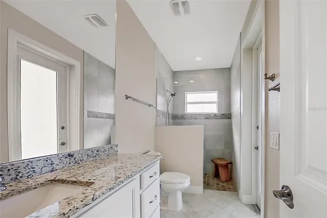 a bedroom with a large bed and a chandelier fan
