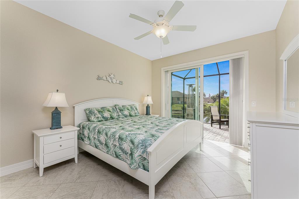 199 Marker Road Rotonda West, FL 33947 - Photo 32 of 55 a bedroom with a large bed and a chandelier fan