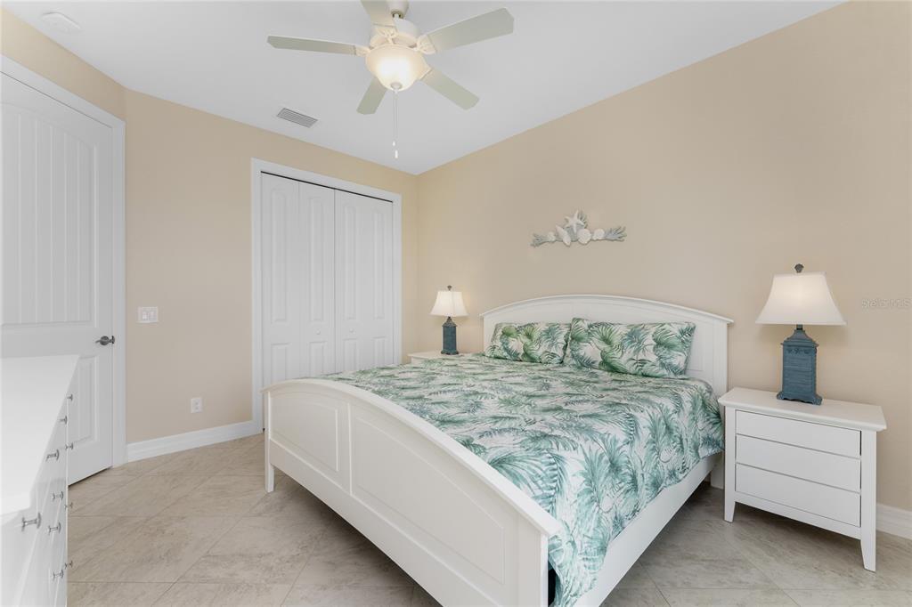 199 Marker Road Rotonda West, FL 33947 - Photo 33 of 55 a bedroom with a large bed and a chandelier