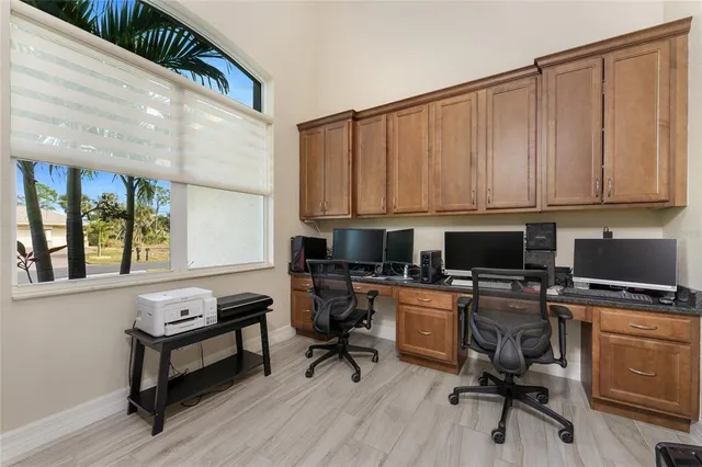 a utility room with stainless steel appliances granite countertop a sink a washer and dryer with wooden floor