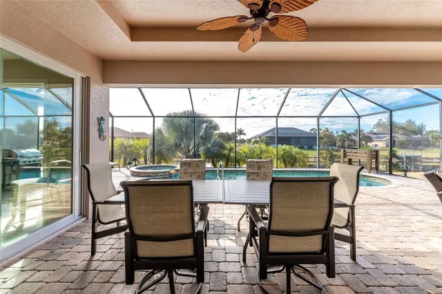 a view of a backyard with swimming pool and sitting area