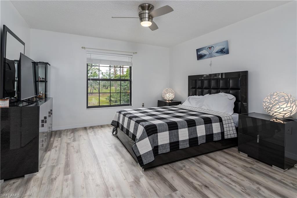 905 Augusta Boulevard, Unit 7 Naples, FL 34113 - Photo 12 of 42 a bedroom with a bed lamp on table and a window