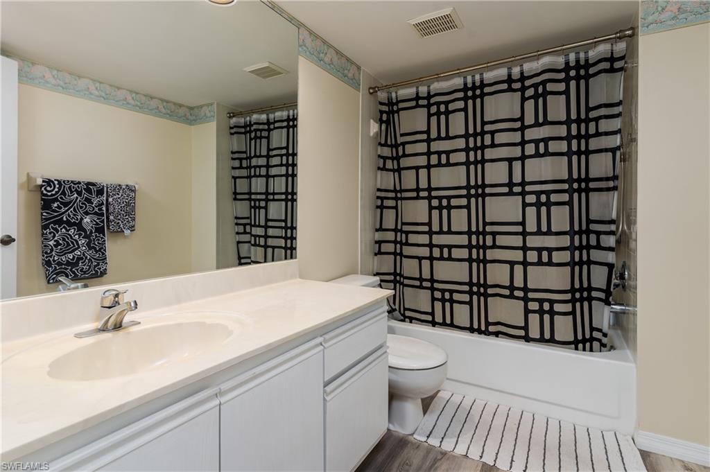 905 Augusta Boulevard, Unit 7 Naples, FL 34113 - Photo 15 of 42 a bathroom with a sink toilet vanity and shower