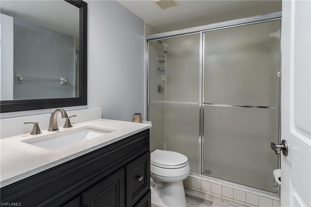 905 Augusta Boulevard, Unit 7 Naples, FL 34113 - Photo 18 of 42 a bathroom with a sink a toilet and shower
