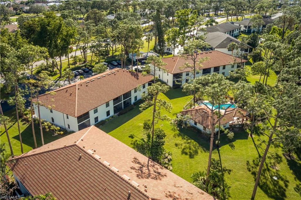 905 Augusta Boulevard, Unit 7 Naples, FL 34113 - Photo 26 of 42 an aerial view of a house with swimming pool and large trees