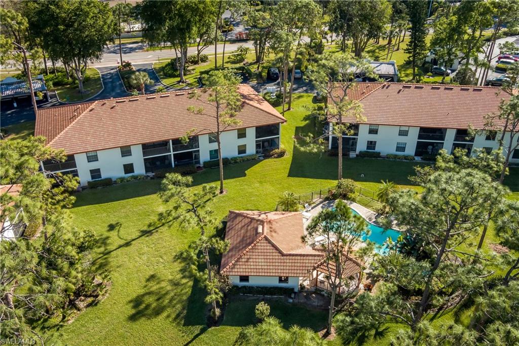 905 Augusta Boulevard, Unit 7 Naples, FL 34113 - Photo 27 of 42 an aerial view of a house with swimming pool lawn chairs and a yard