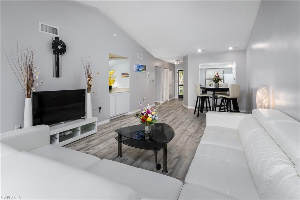 905 Augusta Boulevard, Unit 7 Naples, FL 34113 - Photo 3 of 42 a living room with furniture and a flat screen tv