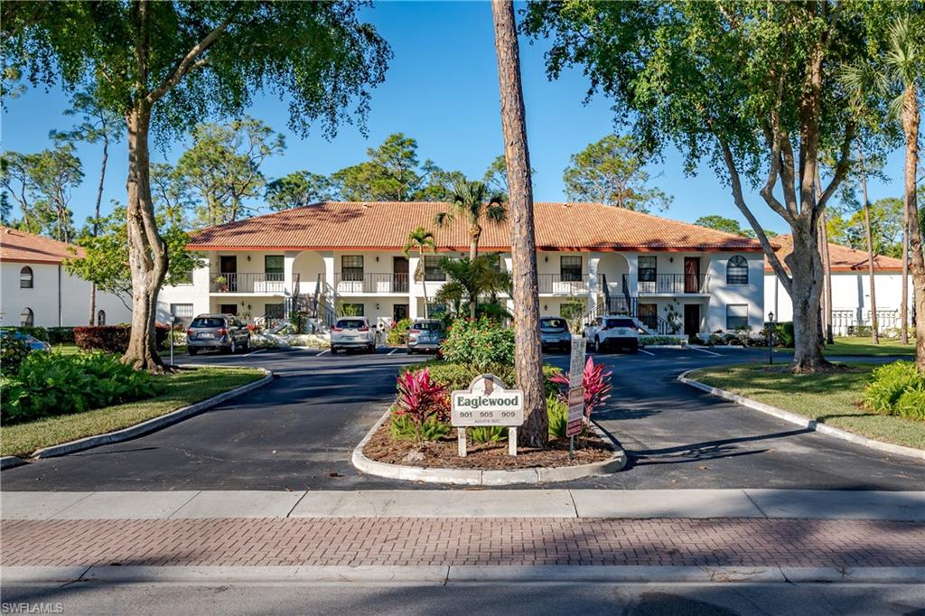 905 Augusta Boulevard, Unit 7 Naples, FL 34113 - Photo 37 of 42 a view of a white house with a yard table and chairs