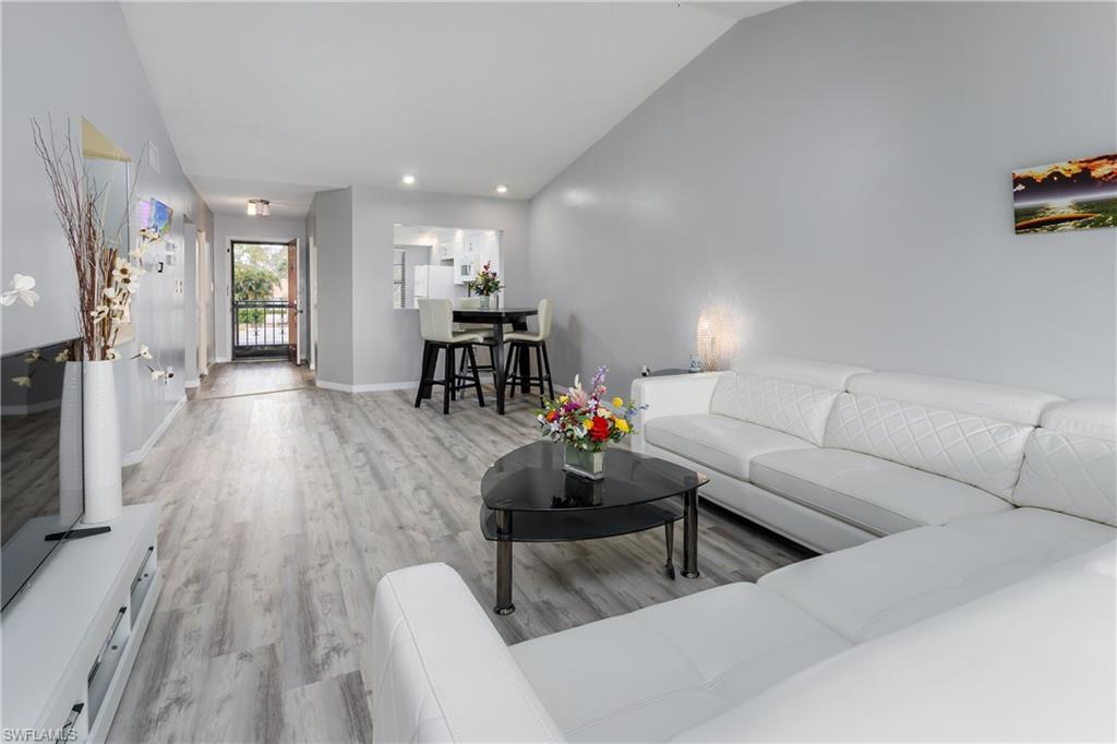 905 Augusta Boulevard, Unit 7 Naples, FL 34113 - Photo 4 of 42 a living room with furniture and a wooden floor
