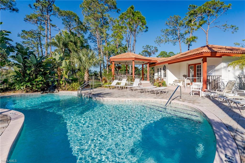 905 Augusta Boulevard, Unit 7 Naples, FL 34113 - Photo 41 of 42 a patio with a table and chairs under an umbrella