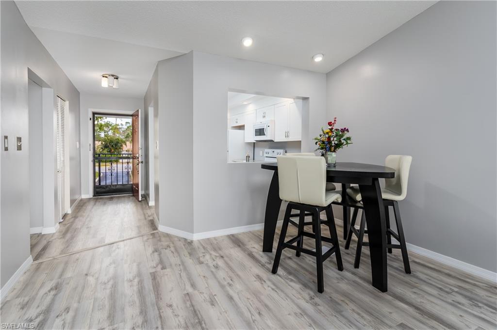 905 Augusta Boulevard, Unit 7 Naples, FL 34113 - Photo 6 of 42 a view of a dining room with furniture and wooden floor