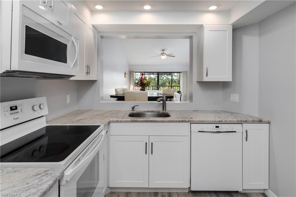 905 Augusta Boulevard, Unit 7 Naples, FL 34113 - Photo 8 of 42 a kitchen with granite countertop white cabinets white appliances and sink
