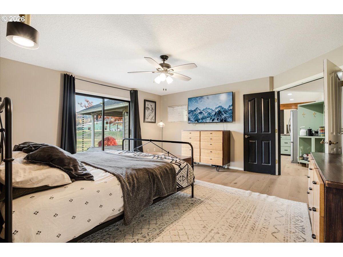 13492 South Warnock Road Oregon City, OR 97045 - Photo 10 of 48 a bedroom with a bed a window and a flat screen tv