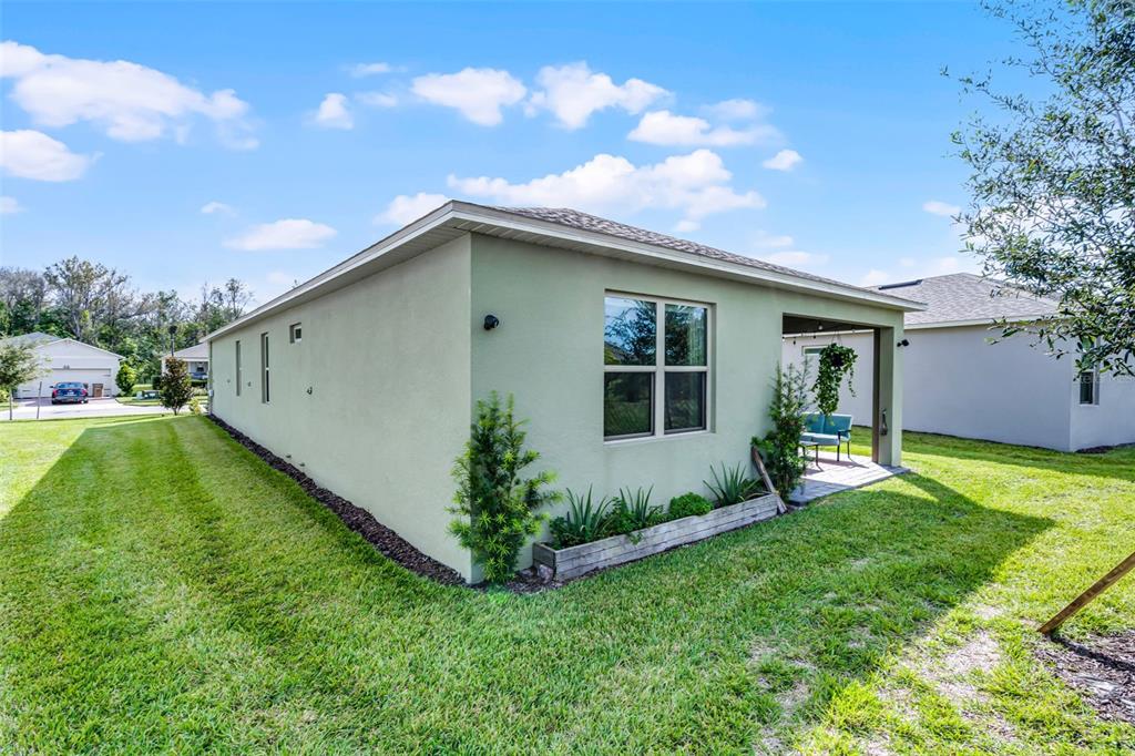3435 Yellowtop Loop Clermont, FL 34714 - Photo 23 of 42 a backyard of a house with table and chairs plants and large tree