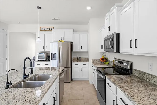 a kitchen with refrigerator cabinets and a sink