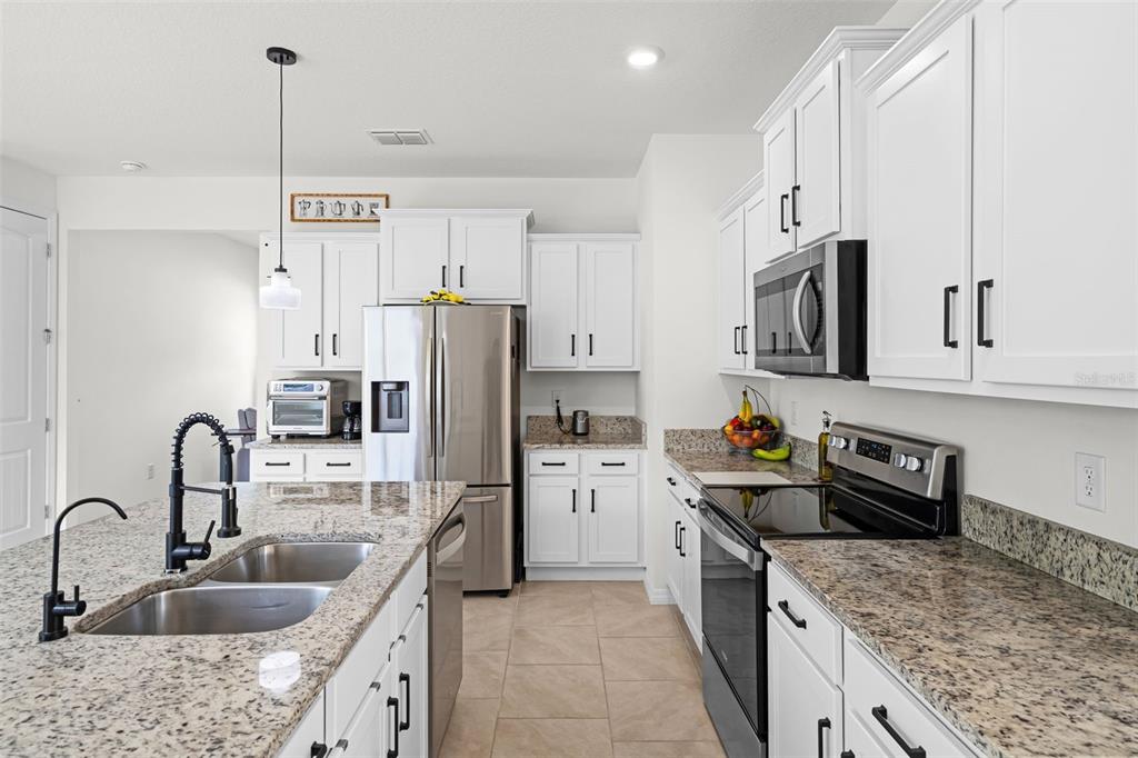 3435 Yellowtop Loop Clermont, FL 34714 - Photo 9 of 42 a kitchen with refrigerator cabinets and a sink