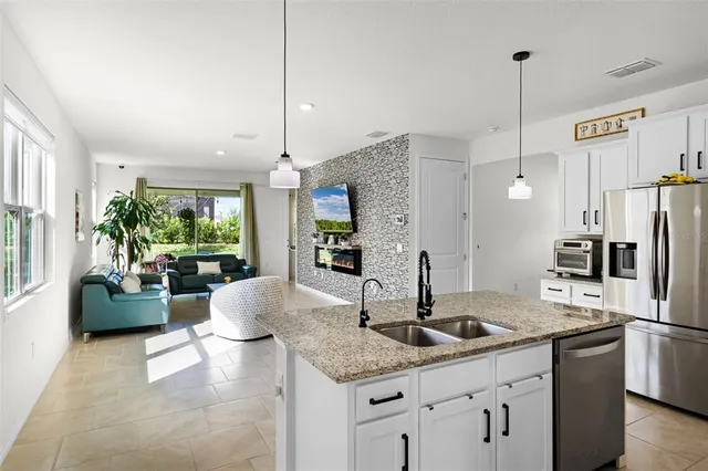 a kitchen with stainless steel appliances granite countertop a sink refrigerator and cabinets