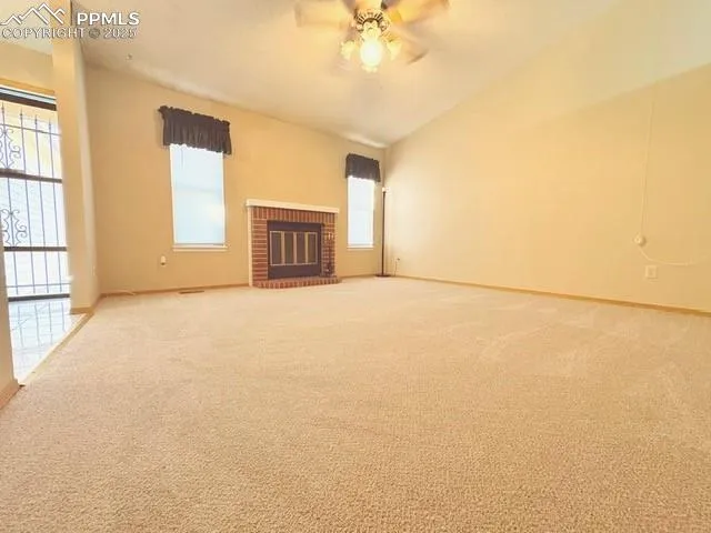 en empty room with windows and fireplace