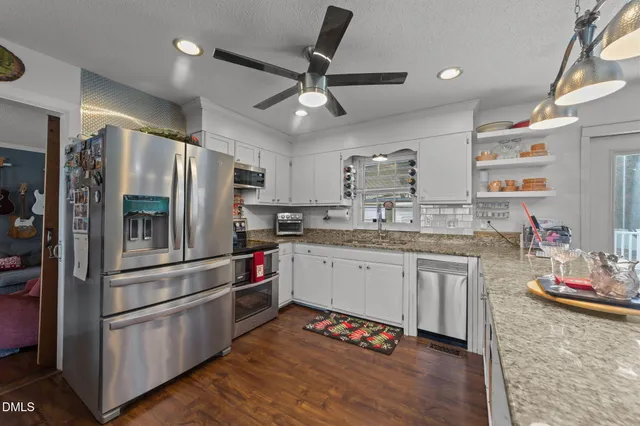 a kitchen with granite countertop stainless steel appliances a sink and counter space