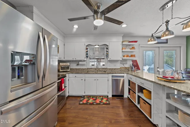 a kitchen with stainless steel appliances granite countertop a sink and cabinets