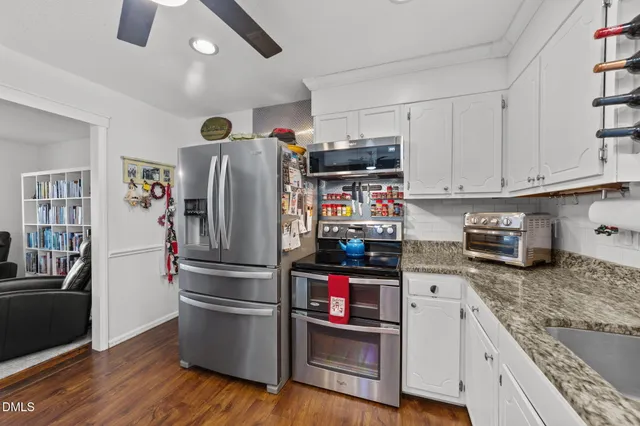 a kitchen with stainless steel appliances granite countertop a refrigerator and a stove