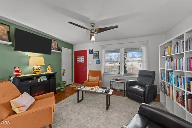 a living room with furniture a rug and a book shelf