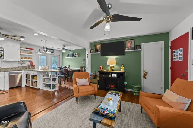 a living room with furniture a flat screen tv and kitchen view