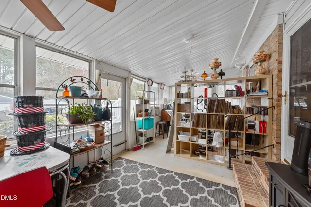 a room with lots of wooden furniture and a potted plant