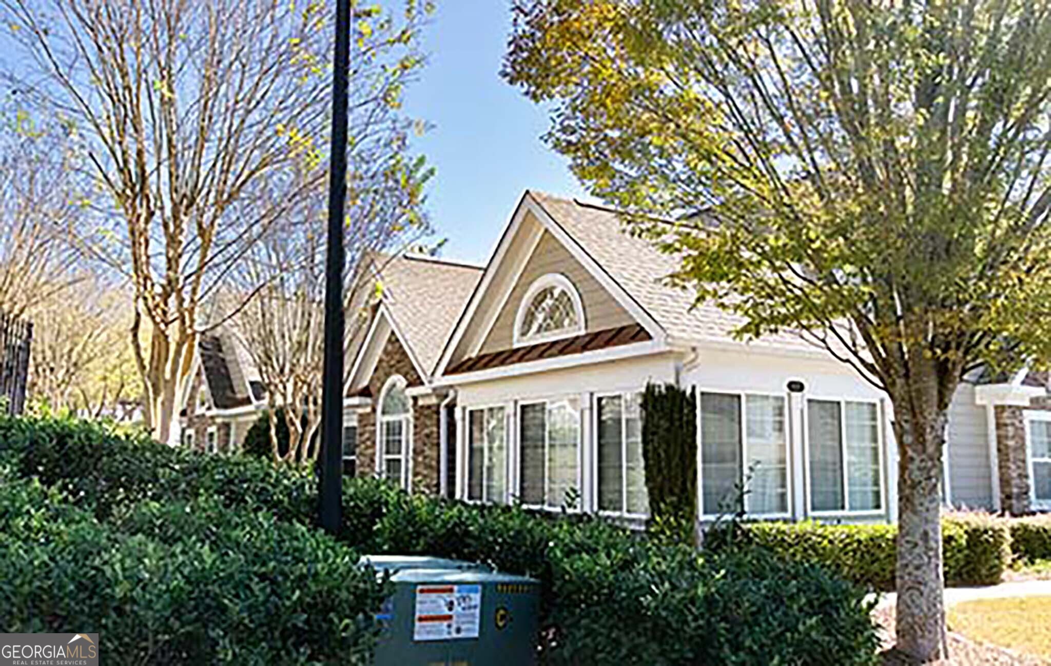 a front view of a house with a tree