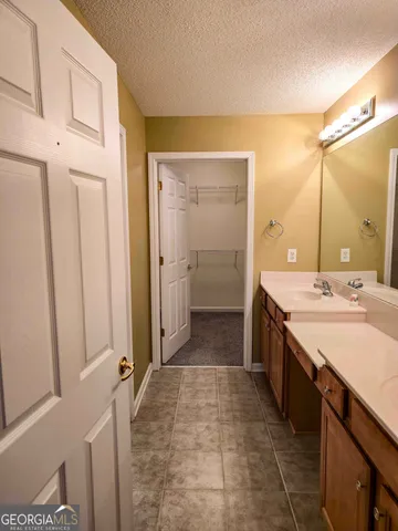 a spacious bathroom with a double vanity sink a mirror and a shower