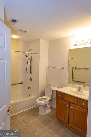 a bathroom with a granite countertop sink a toilet and shower