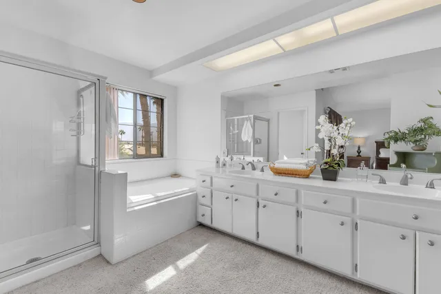 a bathroom with a tub a sink and mirror