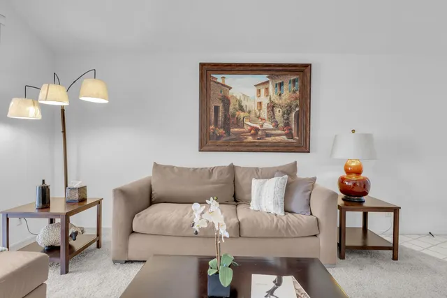 a living room with furniture and a painting on the wall