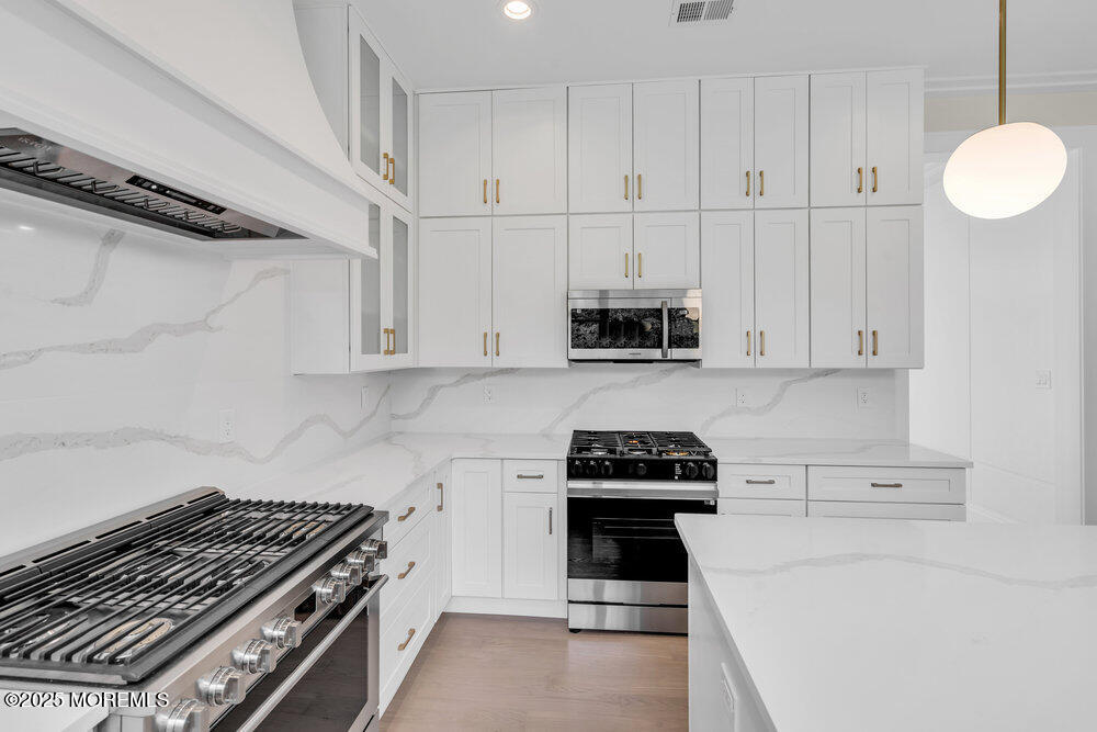 1730 Old Freehold Road Toms River, NJ 08755 - Photo 8 of 31 a kitchen with white cabinets and a stove top oven