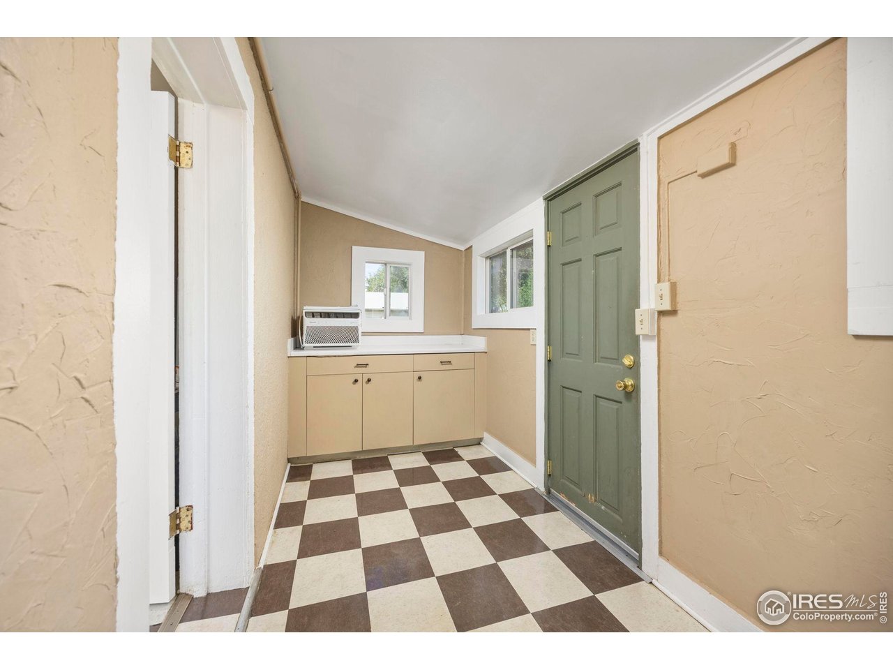 1623 12th Street Greeley, CO 80631 - Photo 25 of 30 a kitchen with a checkered floor and white cabinets